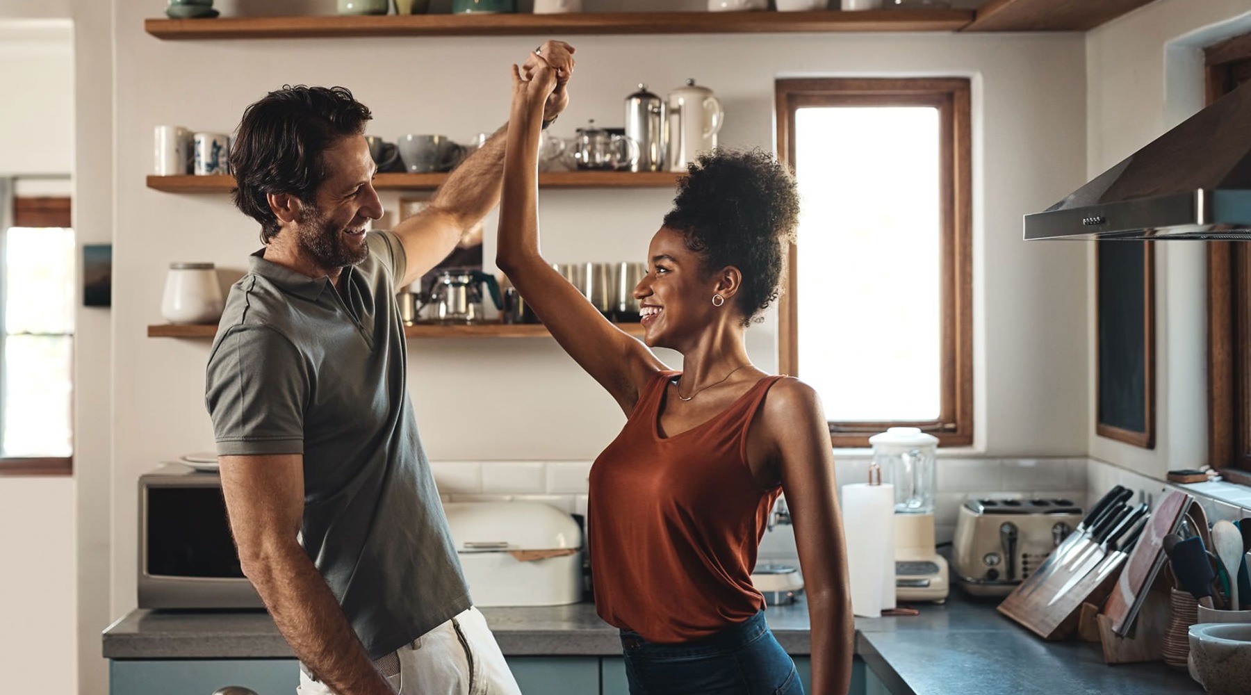a man and a woman smiling at each other in a kitchen